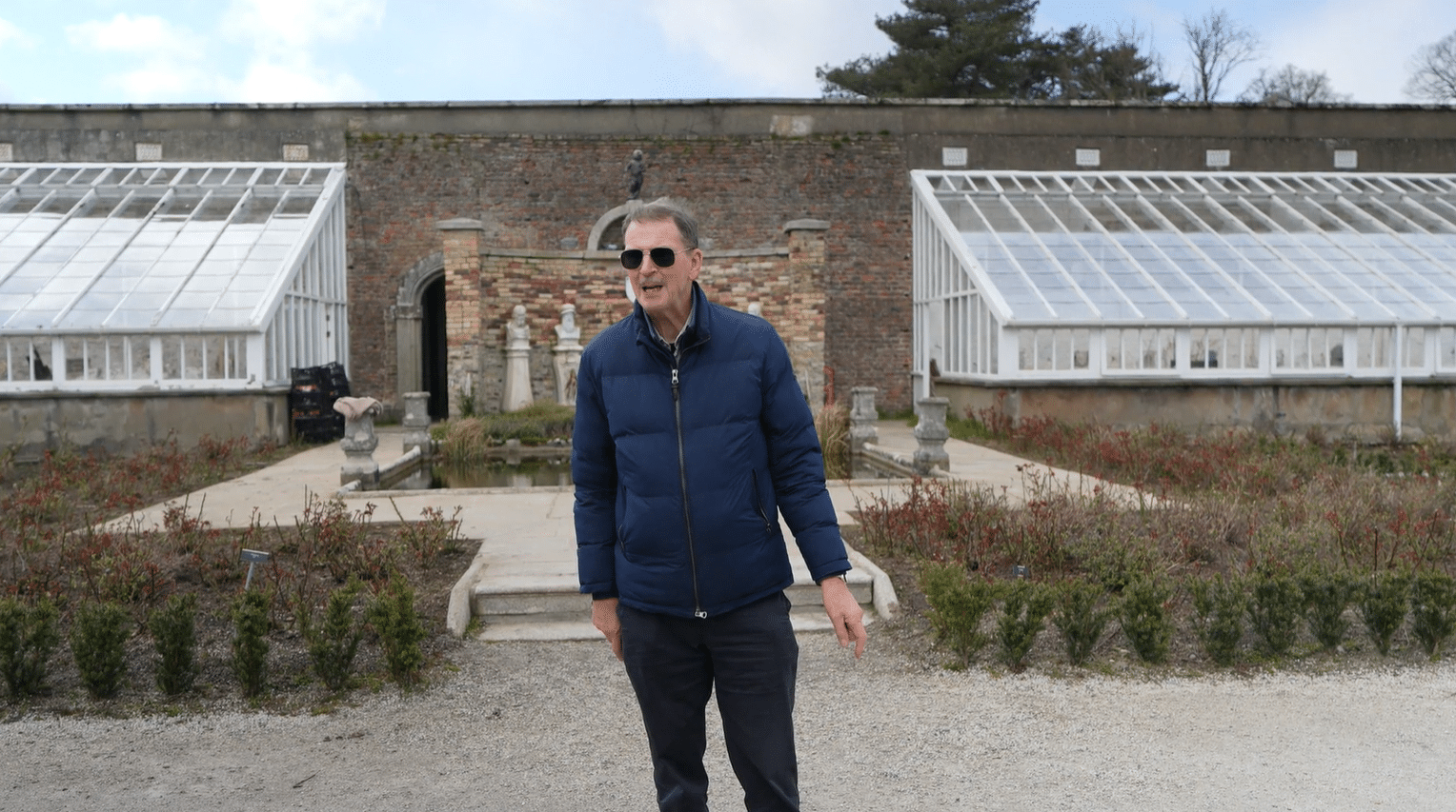 Private Irish tour guide John Ducie standing in front of the Victorian glasshouses at Powerscourt Estate walled garden, Wicklow, on a guided garden tour from Dublin