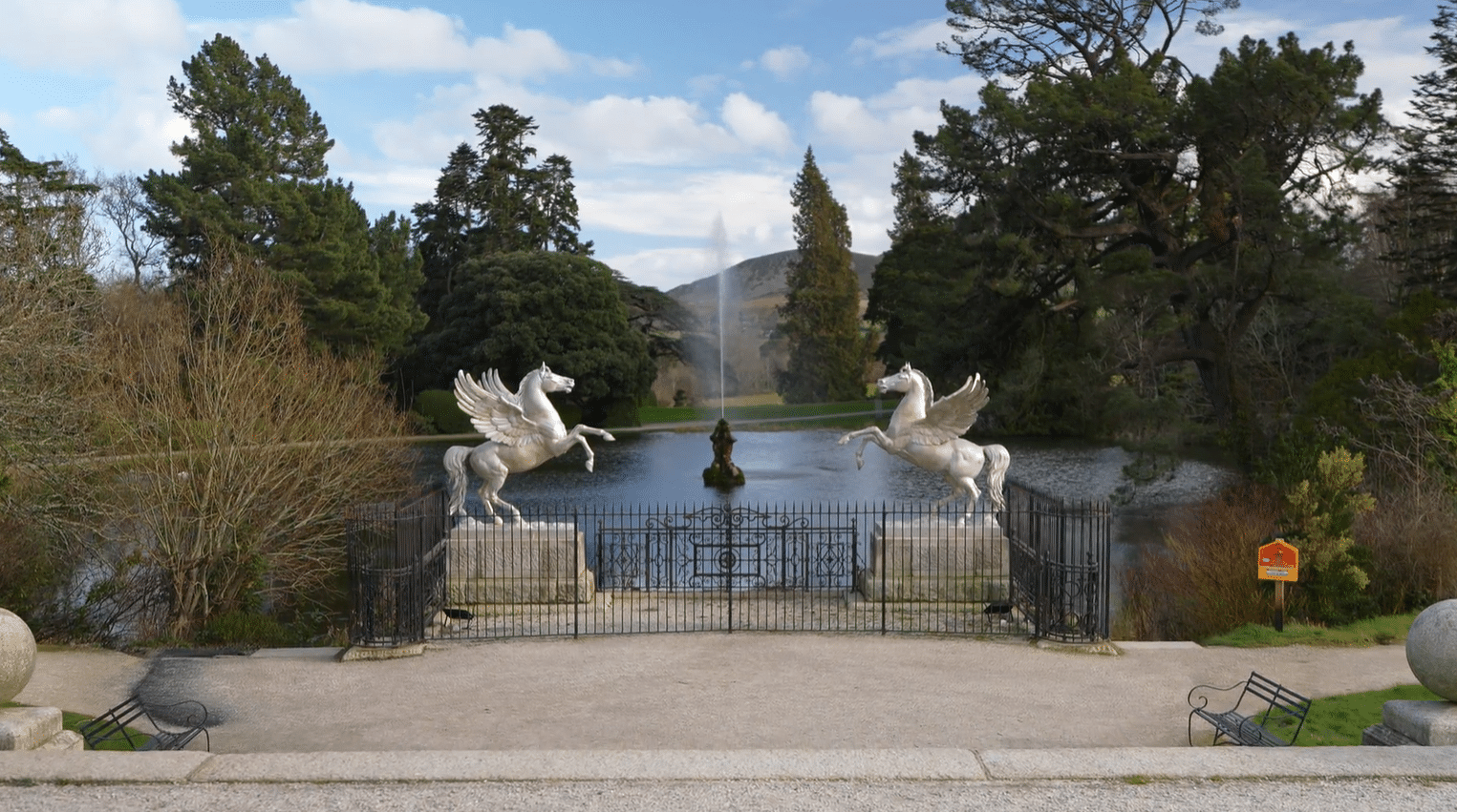Pair of Pegasus statues flanking the ornamental lake at Powerscourt Estate, County Wicklow, Ireland, with the Triton fountain and Wicklow Mountains beyond